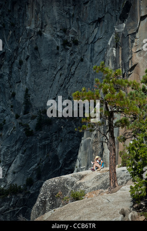 Ein junges Paar, sitzen und Ausruhen auf dem Granit an der Spitze der Nevada fällt. Yosemite-Nationalpark. Kalifornien. USA Stockfoto