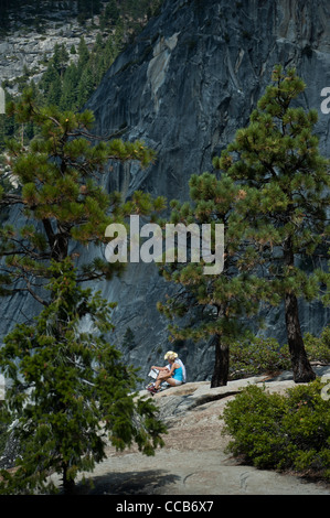 Ein junges Paar, sitzen und Ausruhen auf dem Granit an der Spitze der Nevada fällt. Yosemite-Nationalpark. Kalifornien. USA Stockfoto