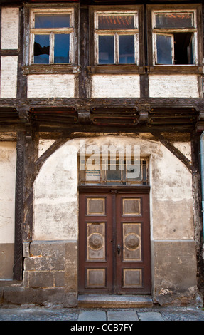 Alte hölzerne Eingangstür und Fenster auf einem verfallenen gerahmte Holzhaus in UNESCO-Stadt Quedlinburg in Sachsen-Anhalt, Deutschland Stockfoto