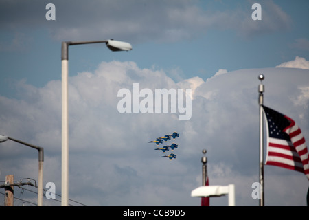 Eingerahmt von Straßenlaternen und die amerikanische Flagge, 6 Flugzeuge der US Air Force Blue Angels Praxis in enger Formation über Lincoln, NE. Stockfoto