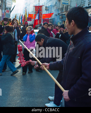 Paris, Frankreich, Menge der chinesischen männlichen Teens Beleuchtung traditionelle Feuerwerkskörper am chinesischen Silvester Karneval in Street im Viertel Marais Stockfoto