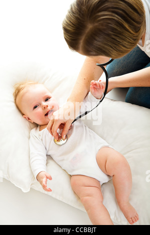 Mutter Abhören Säugling Babymädchen auf weiß Stockfoto