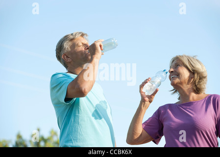 Älteres paar Trinkwasser in Flaschen abgefülltes Wasser im freien Stockfoto