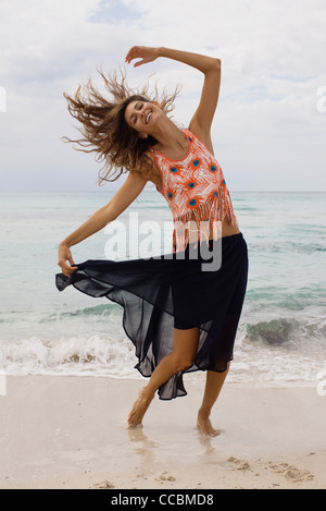 Frau, tanzen und wirft Haar am Strand Stockfoto