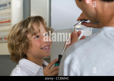 Junge half Vater Befestigung Drähte Stockfoto