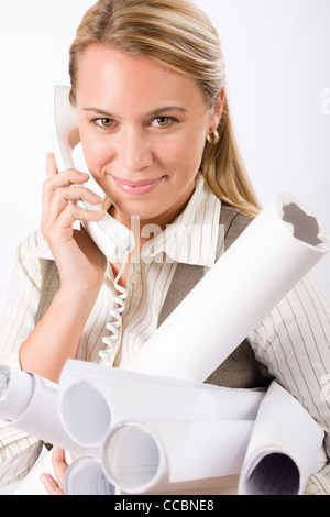 Lächelnde junge Architektin holding Blaupausen isoliert auf weißem Hintergrund Stockfoto