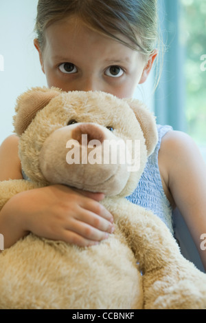 Kleines Mädchen umarmt Teddybär Stockfoto