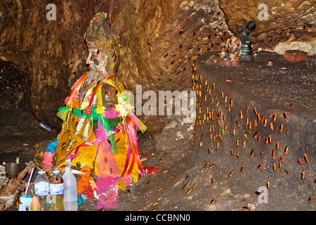 Alte Statuen in einer Höhle am Khao Chong Phran voller Kakerlaken zu ernähren sich von Fledermaus Gauno bewohnen in der Höhle kommen. Stockfoto