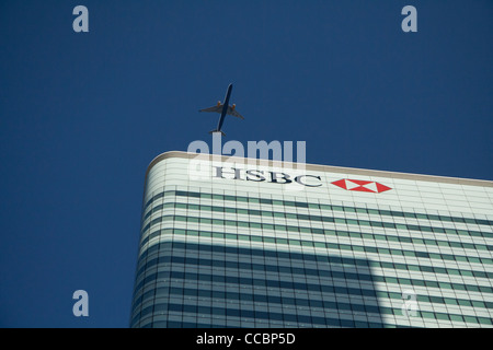 Flugzeug fliegen über HSBC Gebäude in Canary Wharf Stockfoto