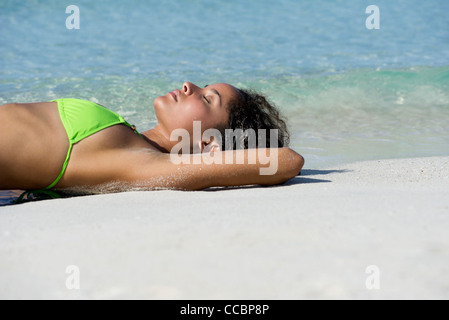 Junge Frau, Sonnenbaden am Strand Stockfoto