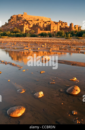 Sonnenaufgang über Ksar Ait Benhaddou in Marokko, mit Riverbed im Vordergrund. Stockfoto