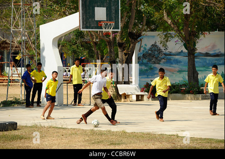 Jungen Fußball spielen auf dem Schulhof in Thailand. Stockfoto