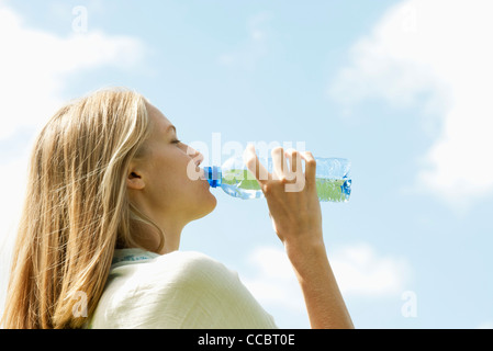 Frau trinkt Mineralwasser Stockfoto