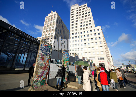 BERLIN, DEUTSCHLAND. Touristen auf der Suche auf Teile der Berliner Mauer am Potsdamer Platz. 2012. Stockfoto