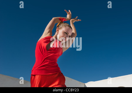 Attraktive Flamencotänzerin, die traditionellen rotes Kleid mit Blume im Haar tragen Stockfoto