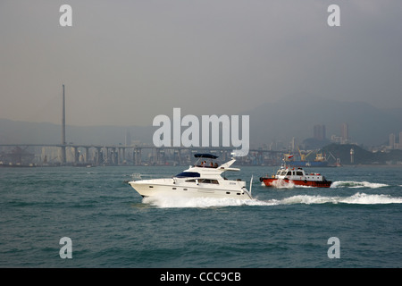 Ausflugsschiff und arbeiten Boot Kreuze Gasstrahler Bucht im Victoria Harbour vor der Steinmetze Brücke Hongkong Sonderverwaltungsregion Hongkong Stockfoto