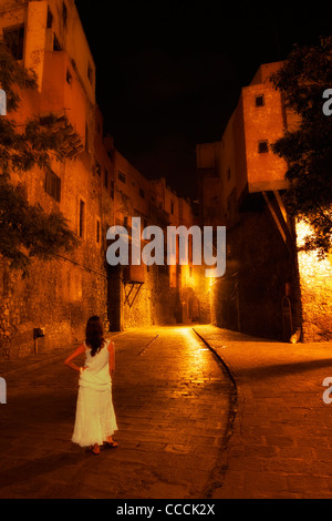 Frau in einem weißen Kleid auf einer Straße in Guanajuato, Mexiko in der Nacht. Stockfoto