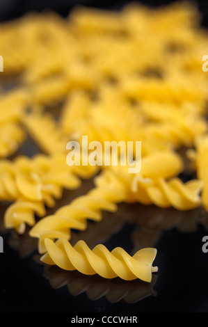 Italienische Pasta Spirale Fusilli über schwarze Closeup DOF Stockfoto