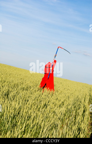 Gespenstische Abbildung in rote Haube mit einer Sense Stockfoto