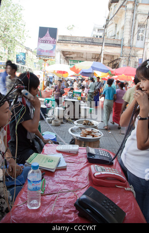 Frau ruft den Straßenmarkt von improvisierten Telefonzelle/Box. Rangun, Myanmar. Stockfoto