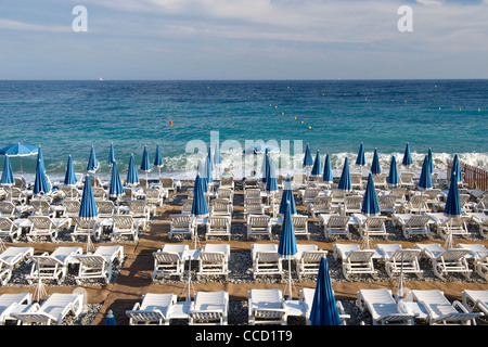 Sonnenliegen am Strand in Nizza an der Mittelmeerküste in Südfrankreich. Stockfoto
