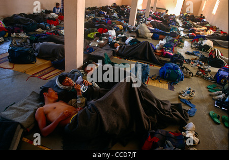 Nepali Young Boys schauen Familienfotos während einer Pause im Gurkha Rekrutierung Auswahl in Baracken Raum, Pokhara-Armee-Camp. Stockfoto