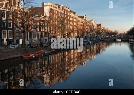 Häuser spiegeln sich an einem ruhigen Winterabend im stillen Wasser der Keizersgracht in Amsterdam, Niederlande Stockfoto