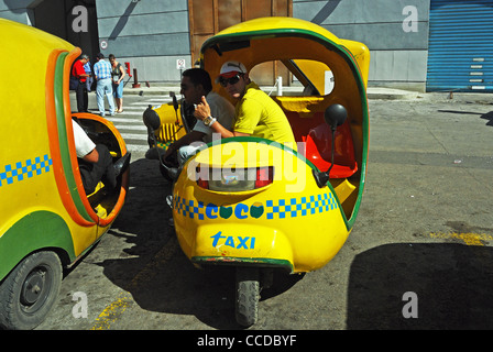 Dreirad-Coco Taxis (so genannt, weil sie eine Kokosnuss ähneln), Havanna (Habana), Kuba, Karibik. Stockfoto