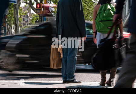 Menschen warten, um an einer Straßenkreuzung in Barcelona, Spanien zu überqueren. Mit einem roten Mann-Stop-Schild darauf hinweist nicht kreuzen. Stockfoto