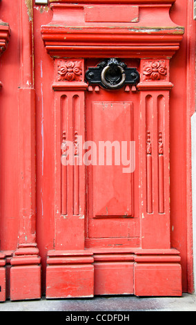 Vintage rote Holztür mit Metallgriff Details Hintergrund. Stockfoto