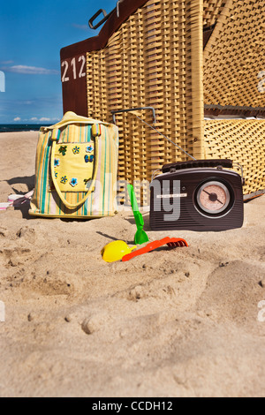 Strand Stuhl, daneben sind ein Radio, eine Strandtasche und Spielzeug für den Strand Stockfoto