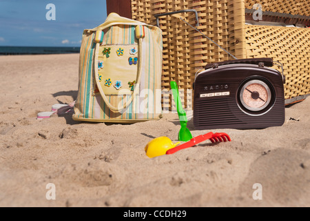 Strand Stuhl, daneben sind ein Radio, eine Strandtasche und Spielzeug für den Strand Stockfoto