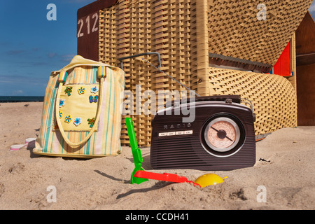 Strand Stuhl, daneben sind ein Radio, eine Strandtasche und Spielzeug für den Strand Stockfoto