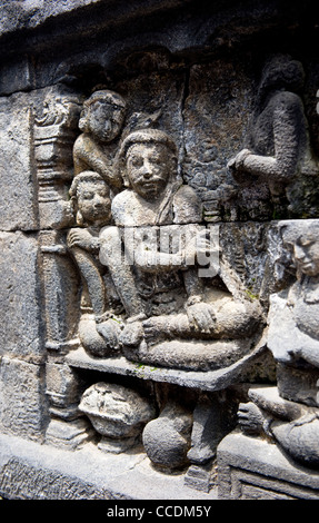 Steinschnitzereien schmücken die Gehwege des buddhistischen Stupa des Borobudur in der Nähe von Yogjakarta, Java, Indonesien. Stockfoto