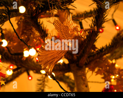 Gold Engel-Weihnachtsschmuck hängt an einem Baum und Weihnachten leuchtet Stockfoto