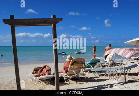 Urlauber am Strand Sonnenbaden, St. Johns, Antigua, Leeward-Inseln, Karibik, West Indies. Stockfoto