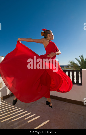 Attraktive Flamencotänzerin, die traditionellen rotes Kleid mit Blume im Haar tragen Stockfoto