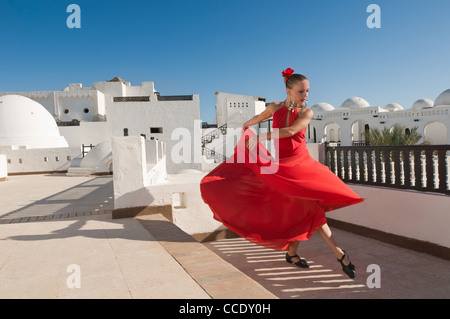 Attraktive Flamencotänzerin, die traditionellen rotes Kleid mit Blume im Haar tragen Stockfoto