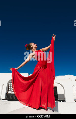 Attraktive Flamencotänzerin, die traditionellen rotes Kleid mit Blume im Haar tragen Stockfoto