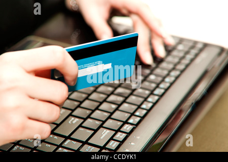 Hände, die Eingabe von Kreditkarteninformationen in einen laptop Stockfoto