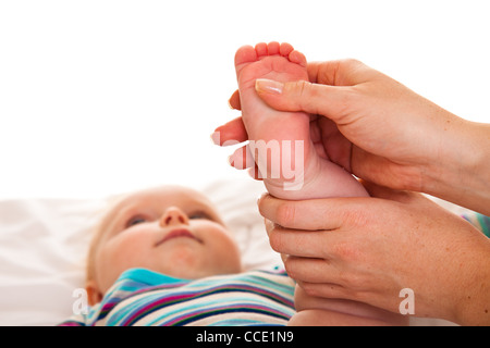 Fußmassage von Säugling Baby isoliert auf weiss Stockfoto