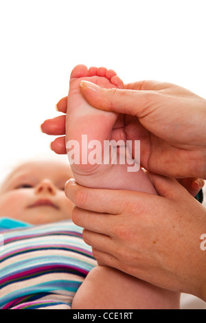 Fußmassage von Säugling Baby isoliert auf weiss Stockfoto