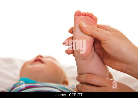 Fußmassage von Säugling Baby isoliert auf weiss Stockfoto