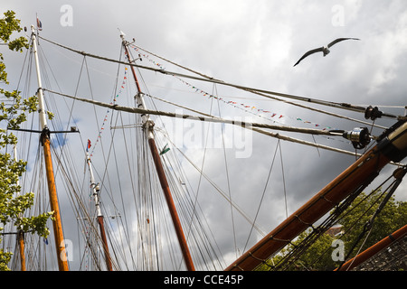 Masten, Seile und Flaggen auf Segelschiffen mit Regenwolken im Hintergrund Stockfoto