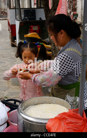 Straßenverkäufer geben frischen Quark Douhua, junge Schulmädchen in Fuli Peoples Republic Of China Stockfoto