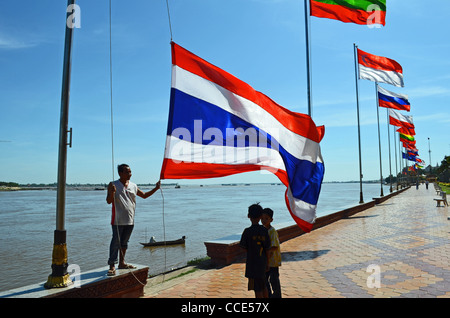 Ein Mann wirft Flaggen am Flussufer in Phnom Penh, Kambodscha Stockfoto