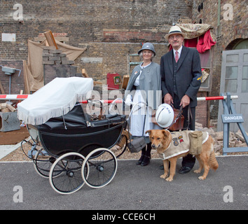 1940er Jahre Gruß an die 40er Jahre Chatham Dockyard UK. Krankenschwester mit Vintage Kinderwagen und Arzt mit Rettungshund. Stockfoto