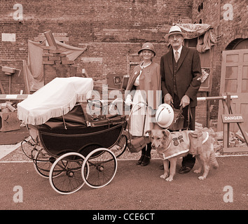 1940er Jahre Gruß an die 40er Jahre Chatham Dockyard UK. Krankenschwester mit Vintage Kinderwagen und Arzt mit Rettungshund. Sepia getönten Digital Stockfoto