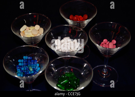 Verschiedene Arten von farbigen Medikamente, Kapseln in dekorativen Gläsern im dunklen Hintergrund. Stockfoto