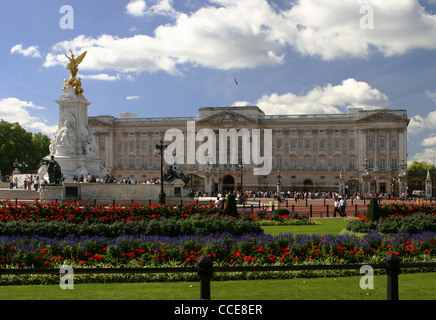 Buckingham Palace an einem sonnigen Tag und Blumen im Vordergrund Stockfoto